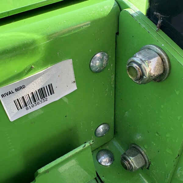 Close-up of lime-green metal machinery with a barcode label reading 'RIVAL 60RD' and several metal bolts/nuts visible.