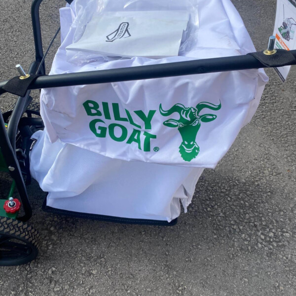 White bag with a green Billy Goat logo mounted on a bicycle trailer, filled with papers wrapped in tissue.
