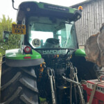 Front view of a green Deutz-Fahr tractor cab with license plate YX24 XKS and a 40 sign visible in the windshield.