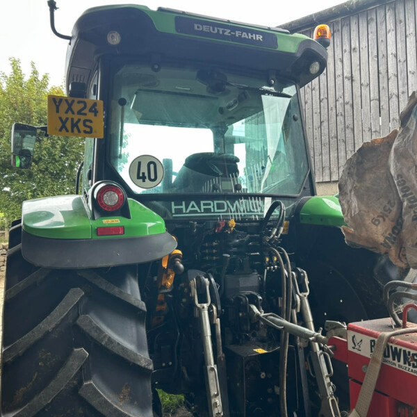 Front view of a green Deutz-Fahr tractor cab with license plate YX24 XKS and a 40 sign visible in the windshield.