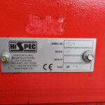 Close-up of a metal identification plate on a red machine, showing serial number 1724 and model VF with a Hi-SPEC logo nearby.