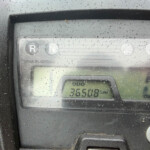 Close-up of a rainy vehicle dashboard with gear indicators R and N and an odometer reading 36508 km