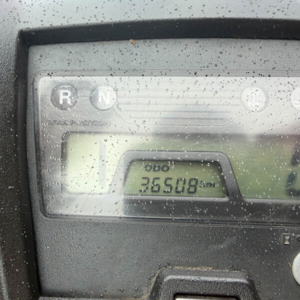 Close-up of a rainy vehicle dashboard with gear indicators R and N and an odometer reading 36508 km