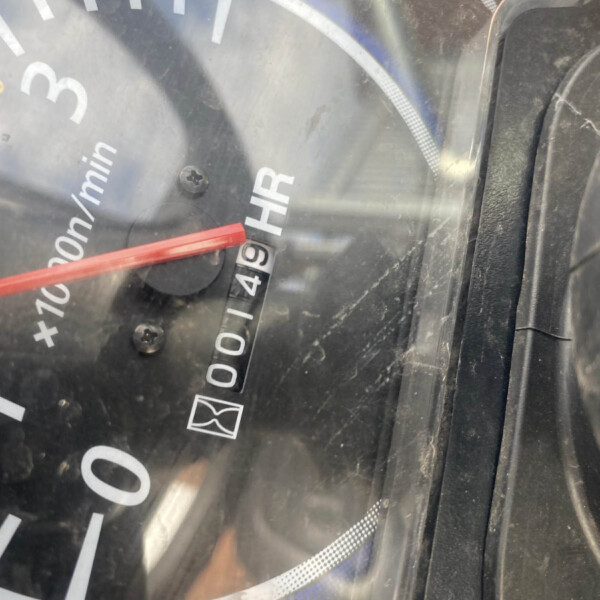 Close-up of a car speedometer at 0 mph with a red needle and 'km/h' markings, through a dusty window.