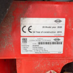 Close-up of a red machine panel with a white KUHN label showing CE mark and model year 2020.