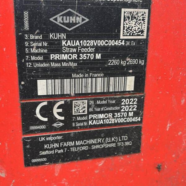 Equipment identification plate on red machinery showing KUHN branding, model Primor 3570 M, serial and barcode details (Made in France).