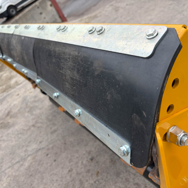 Close-up of a row of bolts securing a metal plate to a yellow industrial machine frame.