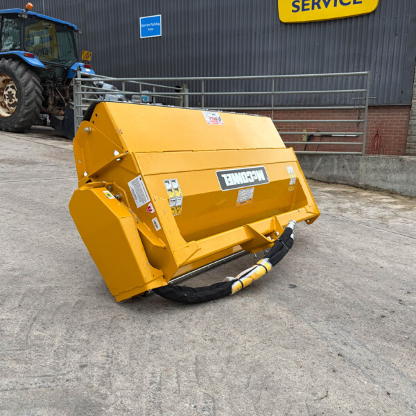 Blue tractor with large rear hydraulic attachment parked beside a bright yellow machine outside a service building with a blue 'Service Parking Area' sign in view.