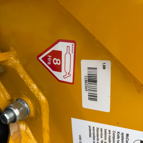 Red diamond hazard label on yellow equipment showing a bottle icon and '8 hrs' warning.