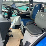 Inside a bus/coach cockpit with steering wheel, mounted tablet, and a blue seat labeled T7.