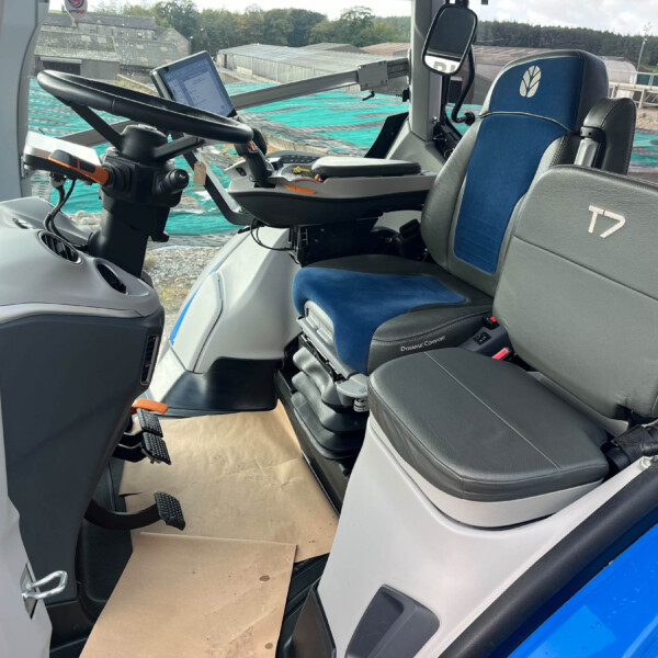 Inside a bus/coach cockpit with steering wheel, mounted tablet, and a blue seat labeled T7.