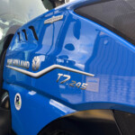 Close-up of a blue New Holland truck cab, showing the Autocommand badge and side air vents.