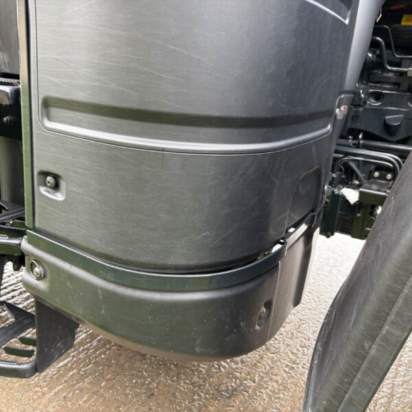 Close-up of a large vehicle's exterior showing black molded panels and chrome step rungs for entry/exit.