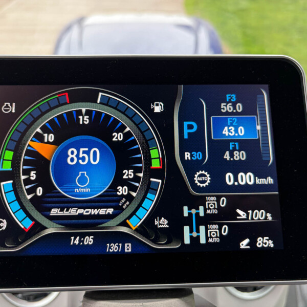 Close-up of a car’s digital instrument cluster showing a circular tachometer with blue accents and a parked gear indicator (P).