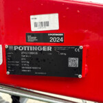 Close-up of a red Pöttinger agricultural implement with a 2024 model label and a barcode sticker.