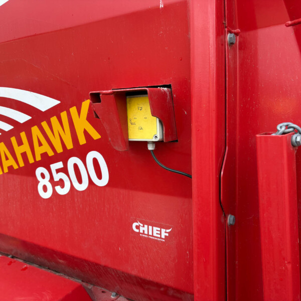 Close-up of a red industrial machine panel with a yellow maintenance label and the CHIEF branding visible on the side.