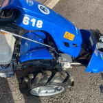 Blue ride-on lawn tractor with the number 618 on the side, viewed from above.