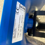 Close-up of a white technical label on a blue metal frame with CE marks and Italian text.