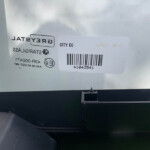 Sticker with a barcode and the text 'CITY EC' on a light metal surface inside a vehicle; label appears partly reversed.