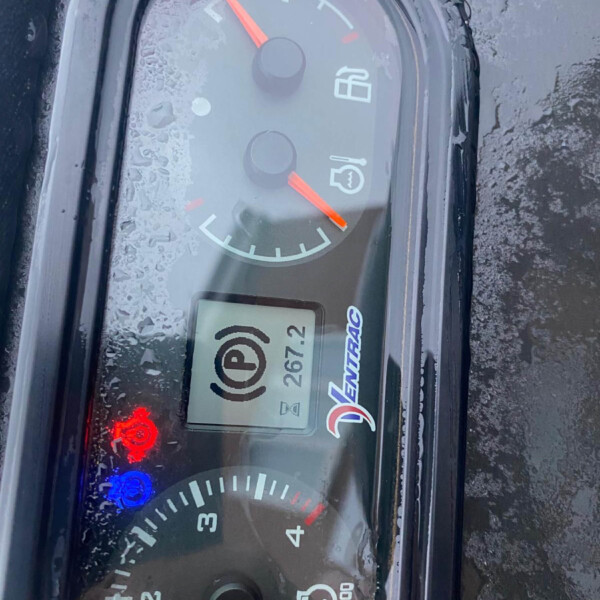 Vehicle instrument cluster with orange needles, frost on the glass, and visible fuel gauge and speedometer.